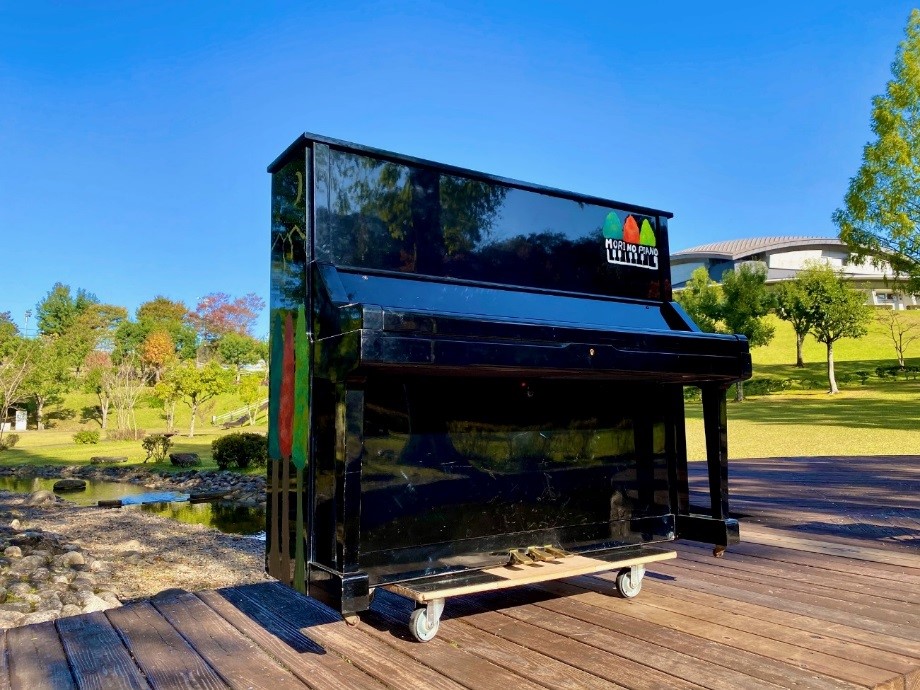 ピアノは、専用の手作りの台車を用いて<br/>四万十会館職員2人で園内を移動している