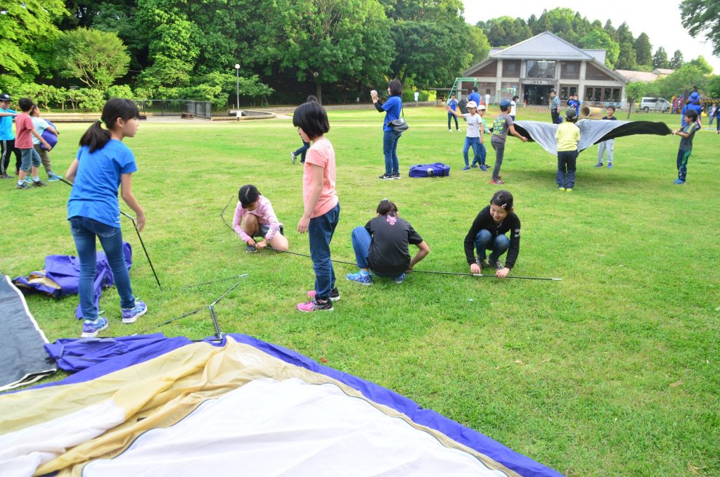 夜は閉園する公園に泊まるため<br/>自分たちでテントを立てる子供たち<br/>（あけぼの山農業公園）