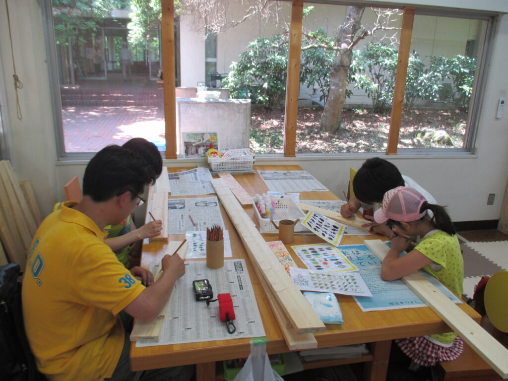 ご参加の家族、板に下絵を描いてグラスデコペンで描く